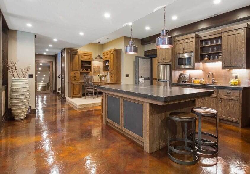A Unique Kitchen With Dark Wood Cabinets, A Large Island, And Glossy, Custom-Epoxy Concrete Floors.