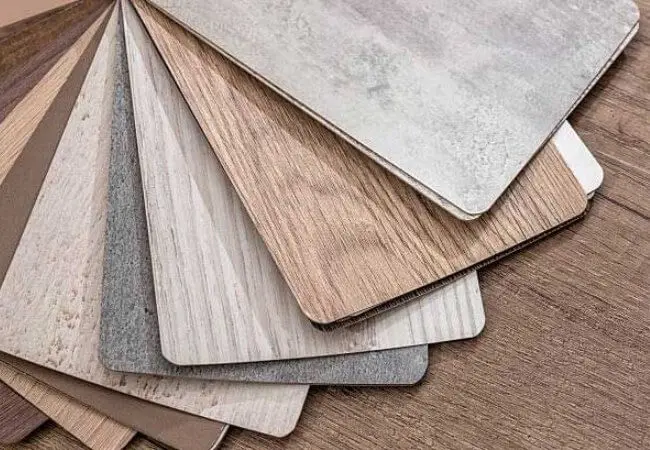 A Close-Up View Of A Fan Of Laminate Flooring Samples In Various Colors And Wood-Look Patterns.